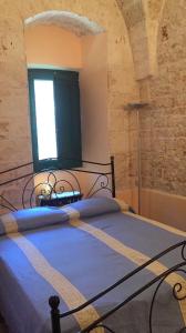 a bedroom with a large bed with a window at Splendida villa a Selva di Fasano in Fasano