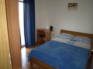 a bedroom with a bed and a table with a chair at Apartmani Adriana1979 in Vodice