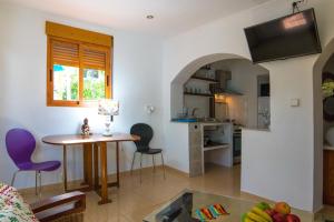 un soggiorno con tavolo e sedie e una cucina di Casa Armonía a Benissa