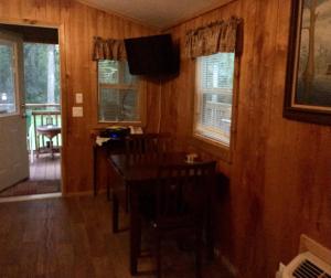 a dining room with a table and chairs and a television at Big Cypress in Lake Panasoffkee