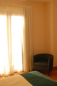 a room with a chair and a window at Hotel Rural Astura in Villacelama