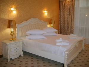 a bedroom with a white bed with white pillows at Hotel Complex Gayki in Zhytomyr