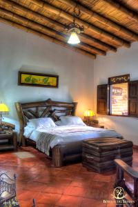 1 dormitorio con 1 cama grande en una habitación en Hotel Bosques Del Saman Alcala, en Quimbaya