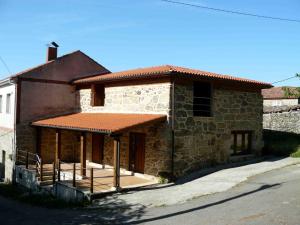 Una casa de ladrillo con un porche en el lateral. en Apartamentos Rurales A Torre, en Santa María