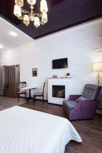 Una sala de estar con un sofá y una chimenea. en Studio on Rymarskaya, en Járkov