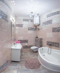 ein Badezimmer mit einer Badewanne, einem WC und einem Waschbecken in der Unterkunft Studio on Rymarskaya in Kharkov