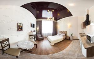Un dormitorio con una cama y un televisor en una habitación. en Studio on Rymarskaya, en Járkov