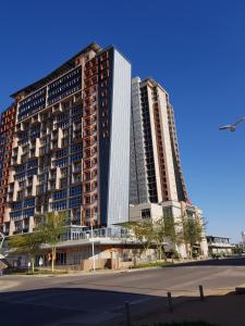 a large building with two tall buildings next to a street at Apartments at Itowers, CBD, Gaborone in Gaborone