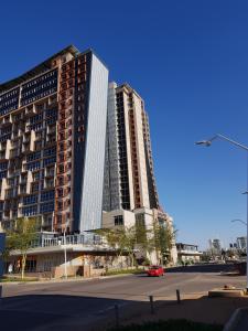 ein großes Gebäude mit einem roten Auto davor in der Unterkunft Apartments at Itowers, CBD, Gaborone in Gaborone