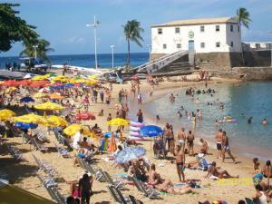 uma multidão de pessoas numa praia com guarda-sóis em Apartamento Edificio Mirage em Salvador