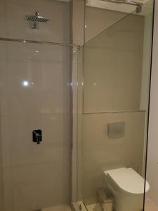 ein Bad mit einer Dusche und einem WC in der Unterkunft Apartments at Itowers, CBD, Gaborone in Gaborone