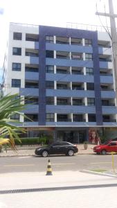 un coche negro estacionado frente a un gran edificio en Apartamento Atlantico Tambaú, en João Pessoa