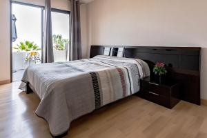 a bedroom with a large bed and a large window at Atalaya court in Adeje +35 photos