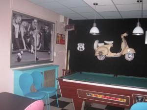 a room with a pool table and a scooter on the wall at Hôtel Le Michelet in Gap