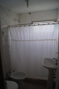 baño con cortina de ducha blanca y lavamanos en Portal Norte en 