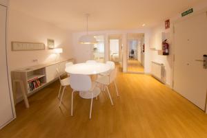een keuken en eetkamer met een witte tafel en stoelen bij Apartamento SoMbrereria RiMboMbin in Burgos