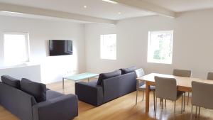 een woonkamer met een tafel en stoelen en een televisie bij Casa da Prelada in Amarante