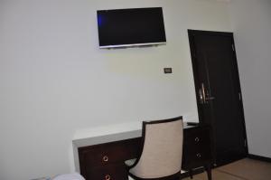 una camera con due sedie e una TV a parete di North Addis Hotel ad Addis Abeba