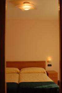 a bedroom with a bed and a light on the wall at Hotel Rural Astura in Villacelama