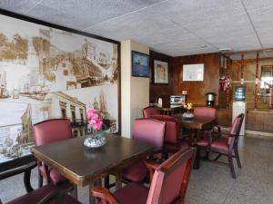 un comedor con mesas, sillas y una pintura en Hotel Premier Saltillo Coahuila, en Saltillo