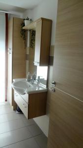 a bathroom with a sink and a mirror at La trifula bianca apts. in Alba