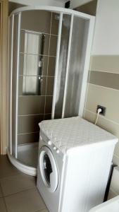 uma máquina de lavar e secar roupa num canto de uma casa de banho em La trifula bianca apts. em Alba