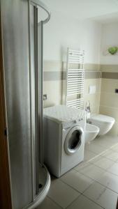 a washing machine in a bathroom with a toilet at La trifula bianca apts. in Alba