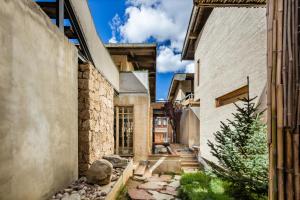 a home with stone walls and a courtyard at Shangri-La Karesansui Hotel in Shangri-La