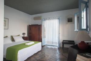 a bedroom with a large bed and a window at Oliaros seaside complex in Agios Georgios