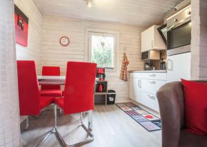 eine Küche mit einem Tisch und roten Stühlen in einem Zimmer in der Unterkunft Ferienhaus Auf der Heide 26-S, Winterberg-Niedersfeld in Winterberg