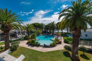 an aerial view of a resort pool with palm trees at Le Spinaker in Le Grau-du-Roi