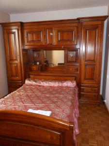 una camera con letto in legno e armadi in legno di La Jasse De Blayac a Roquefort-sur-Soulzon