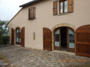 een uitzicht op een huis met houten deuren bij La Jasse De Blayac in Roquefort-sur-Soulzon