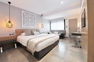 a bedroom with a large bed and a desk at Le Spinaker in Le Grau-du-Roi
