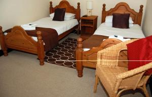 a hotel room with two beds and two chairs at Old Post Office in Shrewsbury