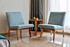 two chairs sitting next to a table in a room at VITS Devbhumi, Dwarka in Dwarka