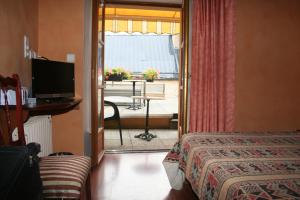 a hotel room with a bed and a view of a patio at Au Bon Accueil in Arvieu
