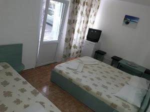 a small bedroom with a bed and a television at Pensiunea Ruxandra in Venus