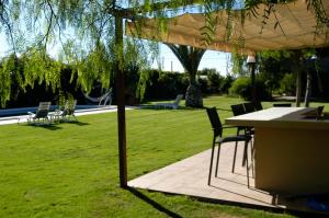 a table and chairs under an umbrella in a park at Los Olivos Villa in Sanlúcar de Barrameda