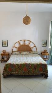 アレネッラにあるCasa Vacanze Arenellaのベッドルーム(キルト付きのベッド付)
