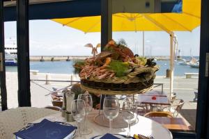 a basket of food sitting on a table with wine glasses at Hotel Atlantique in Le Palais