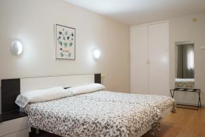 een slaapkamer met een bed met een zwart-witte deken bij AHC Hoteles in Cáceres