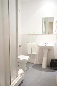 ein weißes Bad mit einem WC und einem Waschbecken in der Unterkunft AHC Hoteles in Cáceres