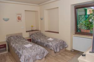 Habitación con 2 camas y ventana en Casa Mots, en Sibiu