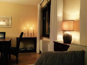 ein Wohnzimmer mit einem Bett und einem Schreibtisch mit einer Lampe in der Unterkunft Appartement St. Barbara in Trier