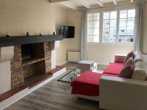 a living room with a fireplace and a red couch at Good Place in Périgueux