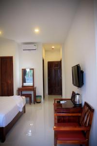 a bedroom with a bed and a table and a tv at Laverder Resort in Phú Quốc