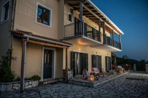 een huis met een balkon en een patio bij Ionian Sensations - Villa Anastasia in Kalamitsi
