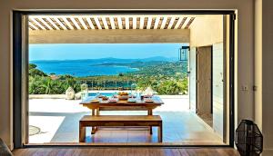 a dining room with a table and a view of the ocean at Santa Rosa in Les Issambres