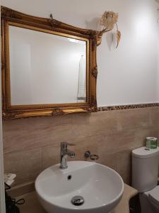 uma casa de banho com um lavatório, um espelho e um WC. em Hotel Porto Azzurro em Giardini Naxos